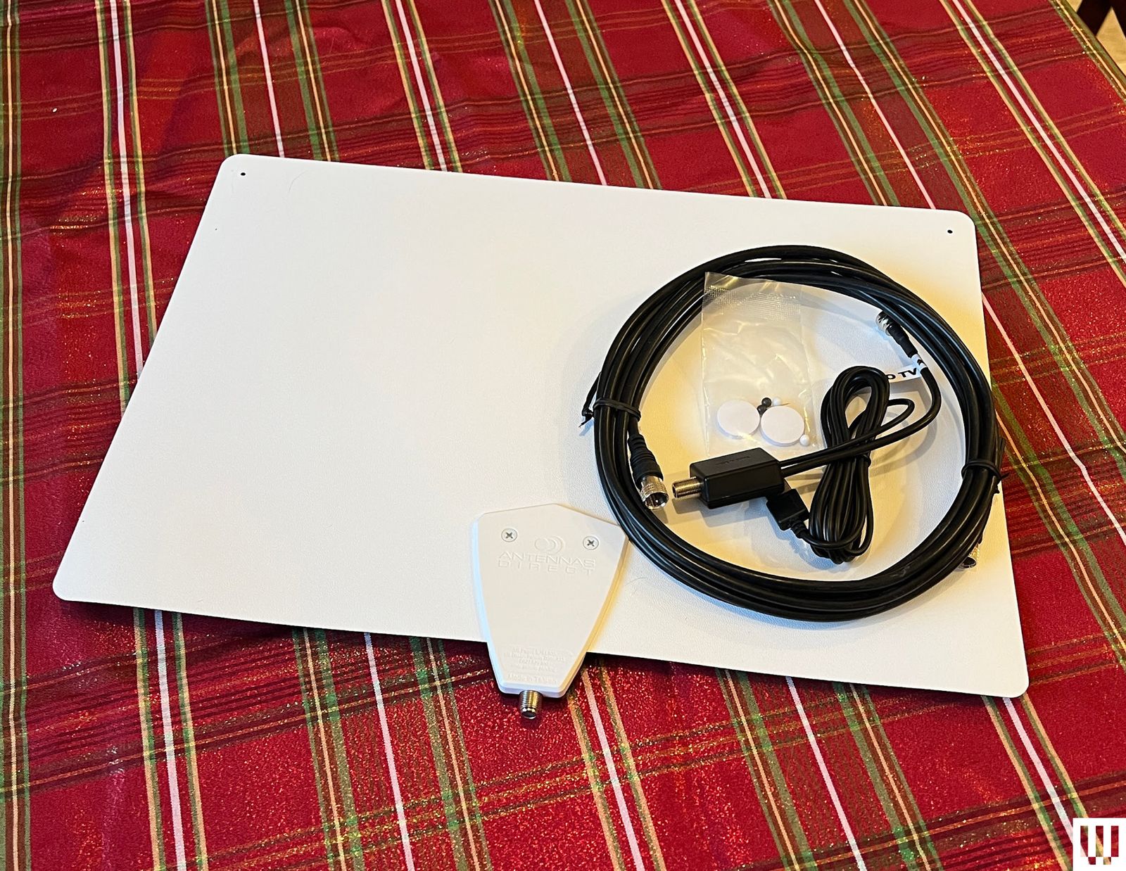 Clearstream Flex Amplified antenna a white panel and wrapped cords on a striped tablecloth
